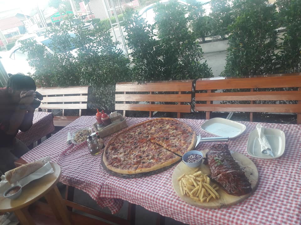 A large pizza and barbecue ribs served at Rose's Roadhouse